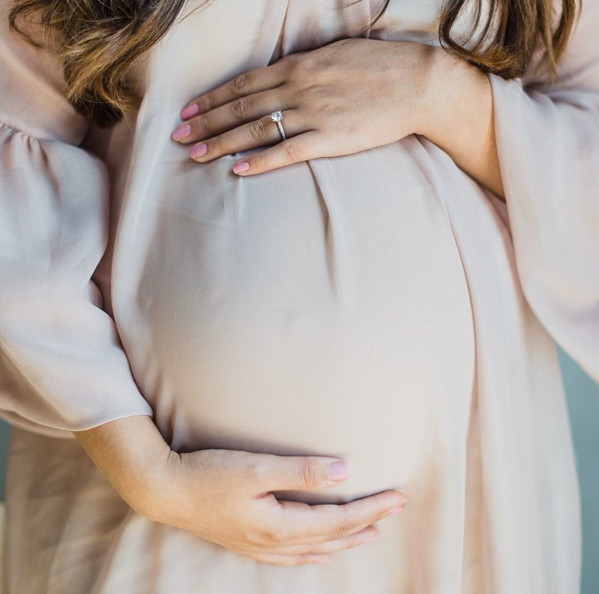 Pregnancy Treatment in Bhopal – Close-up of a pregnant woman gently holding her baby bump, representing safe maternity care and advanced test tube baby center in Bhopal at Maan Hospital.